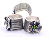 Handmade sterling silver thimbles with floral designs, featured in a charming display for sewing enthusiasts.