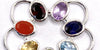 Various colorful gemstones set in silver thimble jewelry design, showcasing artistic craftsmanship and elegance.