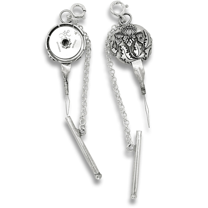Thistle Combination Tool - Needle Threader and Thread Cutter with intricate design and chain linkage for sewing accessibility.