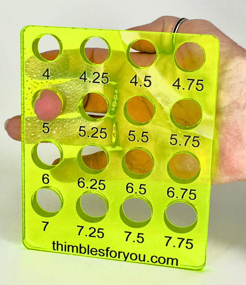 Acrylic Ring Sizer displayed in a hand, showing various size holes for accurate thimble fitting, essential for sewing enthusiasts.