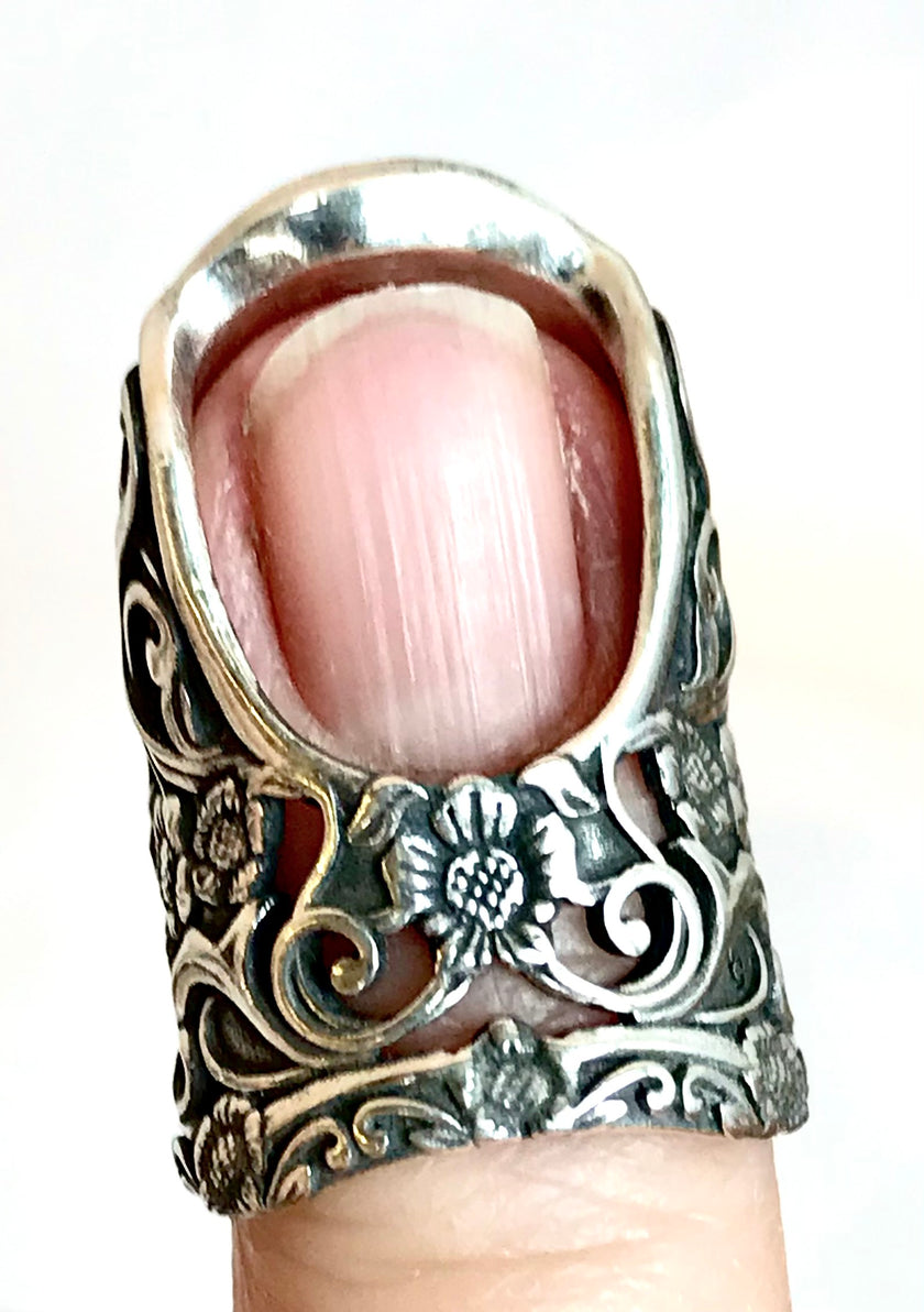 Close-up of a Secret Butterfly Thimble with intricate floral design, showcasing size and craftsmanship, ideal for quilting.