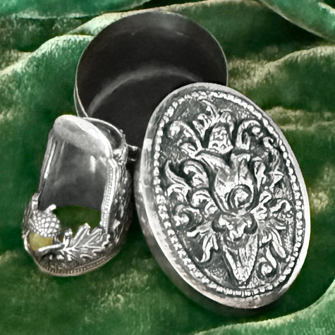 Thimble Box - Oval showcasing a sterling silver thimble and ornate closed-top lid, perfect for thimble collections.
