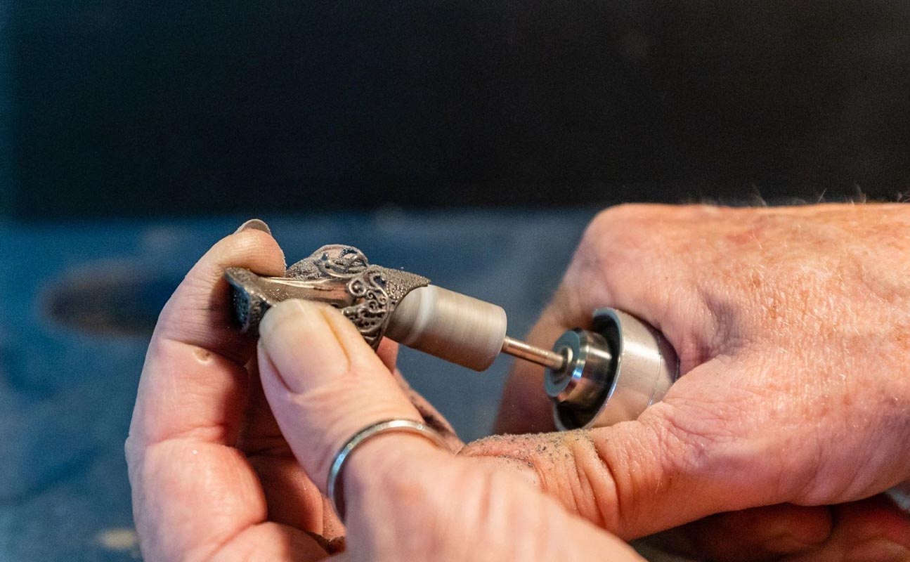 Hand crafting a sterling silver thimble with precision tools for sewing and collectible thimble accessories.