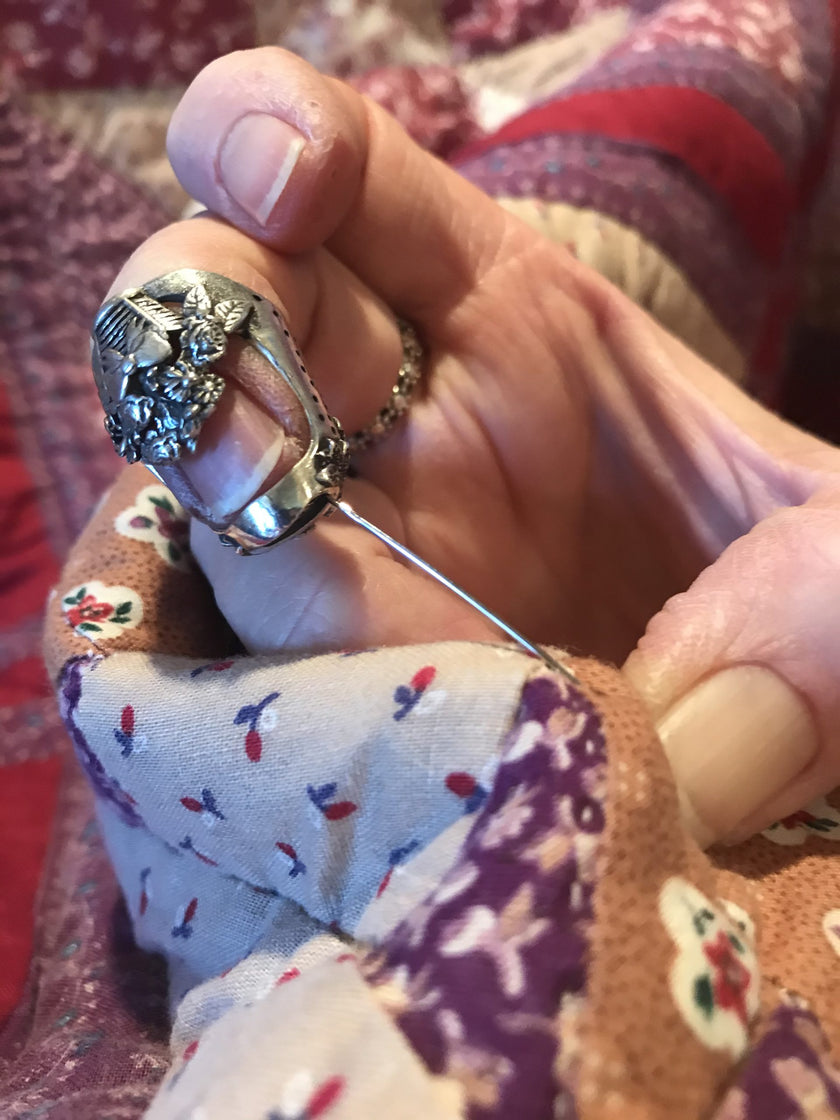 Flower Basket Thimble in use, showcasing its design for quilting with sewing needle and cozy fabric.